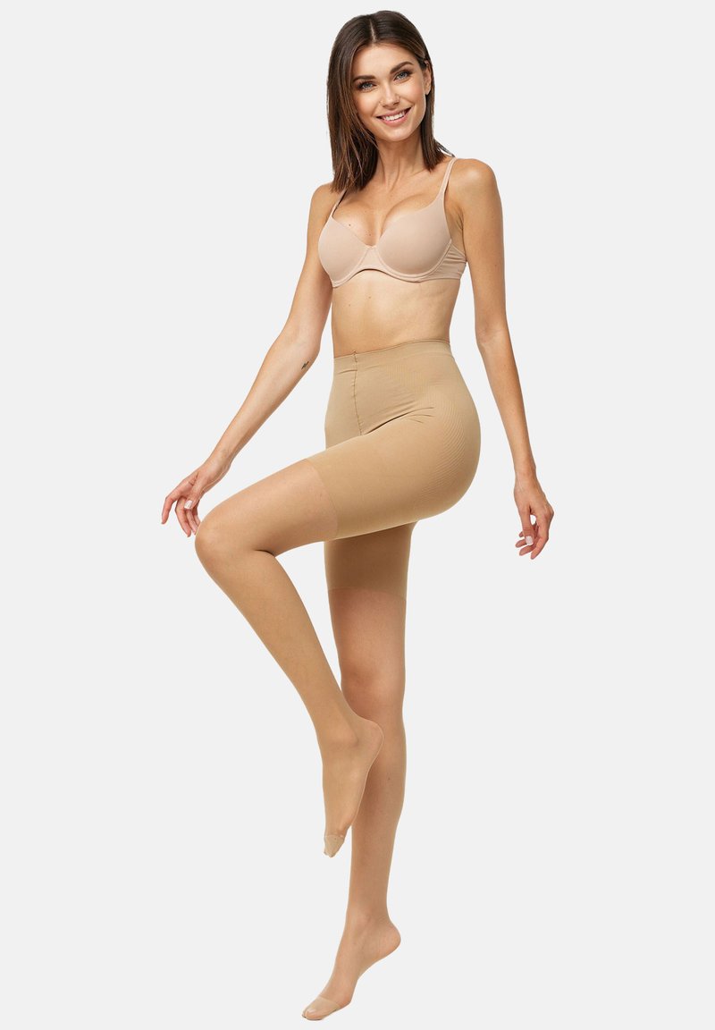 Beige seamless shapewear shorts med en glat tekstur, høj talje-design og en tætsiddende pasform, der strækker sig til midt på låret, ideel til lagdeling.