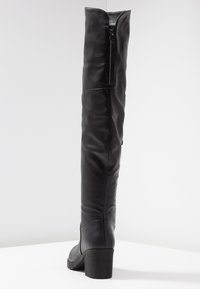 Bota negra de cuero hasta la rodilla con diseño ajustado, cremallera trasera y tacón cuadrado. Textura lisa con detalles sutiles de costura.