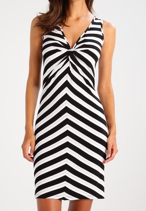 Ärmelloses schwarz-weiß gestreiftes Kleid mit V-Ausschnitt und Chevron-Muster, figurbetonte Silhouette, endet oberhalb des Knies.