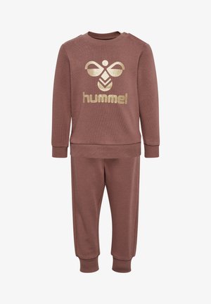 Dwuczęściowy zestaw w miękkim, brązowym materiale. Składa się z bluzki z długim rękawem z złotym logo oraz pasujących spodni z prążkowanymi mankietami. Prosty fason.