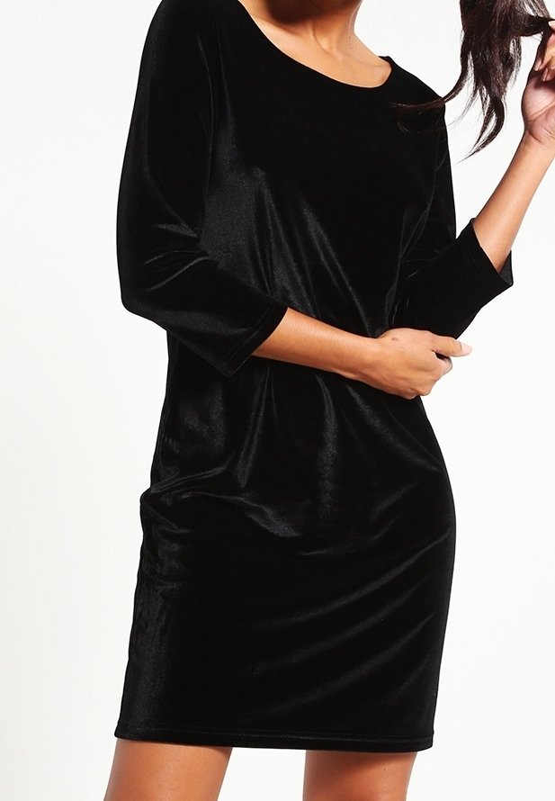 Schwarzes Samtkleid mit rundem Ausschnitt und Dreiviertelärmeln. Der Stoff hat eine glatte Textur und eine figurbetonte Silhouette.
