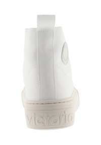 Sneaker alta in canvas bianco con finitura texturizzata, suola in gomma, linguetta sul retro e logo in rilievo sul tallone.