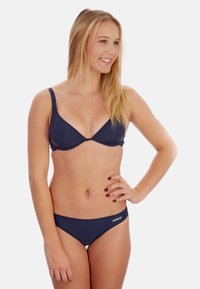 Navyblaues Bikini-Set mit einem dreieckigen Oberteil mit dünnen Trägern und einem passenden tief sitzenden Unterteil, gefertigt aus glattem, dehnbarem Stoff.