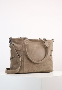 Taupe mocka-handväska med två handtag, ett avtagbart axelband och flera dragkedjefickor för förvaring.