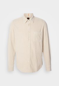 Chemise en velours côtelé beige à manches longues, avec patte de boutonnage devant, poche poitrine et col pointu sur fond uni.