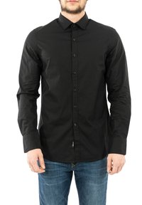 Camisa negra de manga larga hecha de tela s�ólida, con cuello, cierre de botones y un diseño ajustado. Combinada con jeans azules.