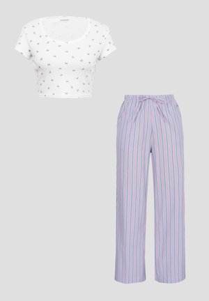 Hvid cropped t-shirt med små trykte sommerfugle og højtaljede lavendelbukser med blå lodrette striber og snøre i taljen.