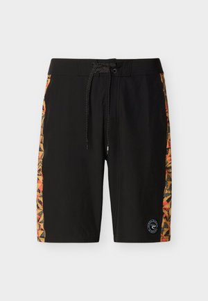 Pantalones cortos negros con paneles laterales geométricos multicolores y cintura con cordón negro, con un pequeño logo circular cerca del dobladillo.