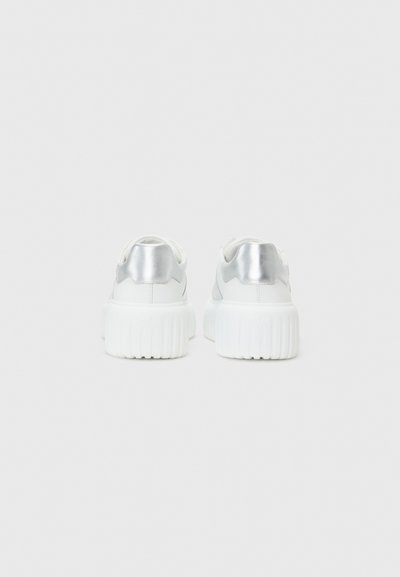 Des baskets blanches avec une semelle blanche épaisse et des accents argent métallisé à l'arrière. Matériau lisse avec un design élégant.