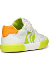 Baskets blanches avec des accents verts et jaunes, dotées d'une bride Velcro, d'une semelle en caoutchouc texturé et d'un onglet de talon orange contrastant.