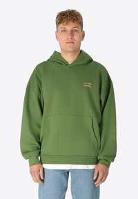 Grüne Kapuzenjacke aus weichem Material, mit einer großen Fronttasche und einem Logo-Design auf der Brust. Lässiger Schnitt mit langen Ärmeln.