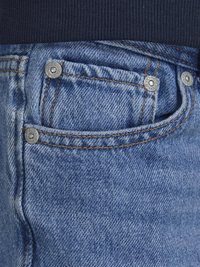 Jeans in denim blu con un taglio classico, dotati di rivetti in argento, cuciture a contrasto e una piccola tasca frontale. Si può notare una texture morbida.