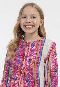 Spalvota raštuota striukė su rožinėmis, mėlynomis ir geltonomis detalėmis. Pagaminta iš tekstūruotos medžiagos, su žalvariniais mygtukais ir apvalia iškirpte.