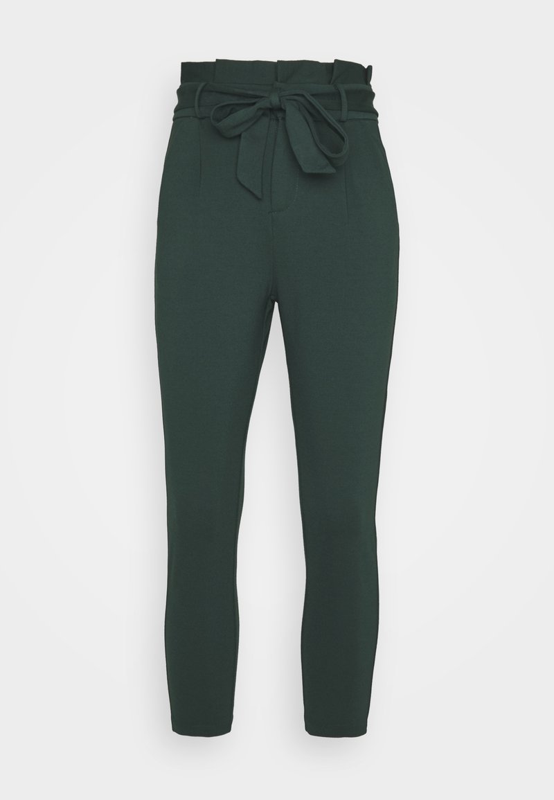 Pantalon fuselé vert foncé taille haute avec ceinture à nouer en tissu et taille paperbag, vu de face sur fond uni.
