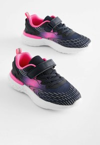 Baskets sportives avec un dessus bleu marine, des accents roses et une semelle blanche. Comprend une sangle Velcro, un motif texturé et un dégradé de couleurs contrasté.