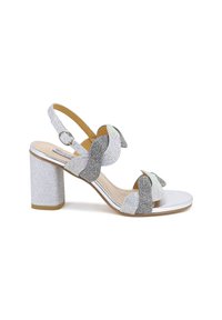 Sandalo con tacco a blocco in glitter argento, dotato di due fiocchi decorativi, adornato con strass trasparenti e iridescenti, e con una fascia e una suola metallica.