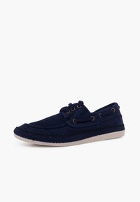 Navy blue canvas shoe with white rubber sole, stitched detailing, brass eyelets, lace-up design, and rounded toe. Soft texture.
