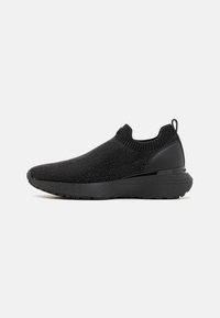 Mustuvad libisemiseks mõeldud sneakersid, millel on kudumisega ülemine osa, tekstuuriga viimistlus ja voolujooneline disain. Omab paksu talla ja taga tõmbeaasat.