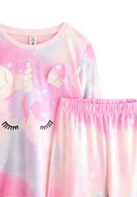 Completo pigiama a tema unicorno in morbido tessuto rosa e viola, con un volto di unicorno e orecchie sulla parte superiore e pantaloni con cintura elastica coordinata.