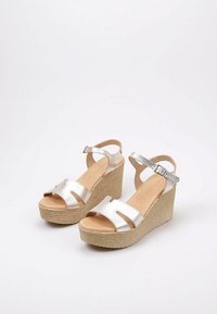 Sandalias cuña plateadas con un upper texturizado, diseño de punta abierta, tira en el tobillo y suela estilo cuerda natural.