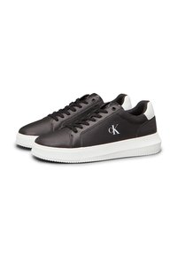 Schwarze Ledersneaker mit weißer Gummisohle, runder Zehenpartie und Schnürdesign. Mit CK-Logo an der Seite und kontrastierenden weißen Akzenten an der Ferse.