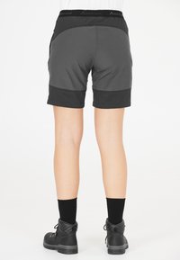 Svarta och grå shorts med en slät textur, med en bred midja och en kontrasterande nederdel. Kombination med svarta kängor och strumpor.