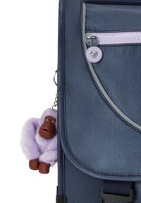 Marinblå tygryggsäck med en framficka med dragkedja, prydd med en lila fluffig nyckelring formad som en gorilla. Silverfärgade detaljer.