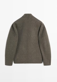 Giacca in misto lana grigia con colletto alto, spalle abbassate e design minimalista, con schiena dritta e senza chiusure visibili.