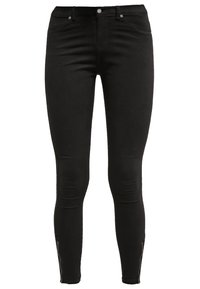 Jeans ajustados negros hechos de tela de mezclilla, con una textura suave, talle alto y cremalleras en los tobillos como detalles de diseño destacados.