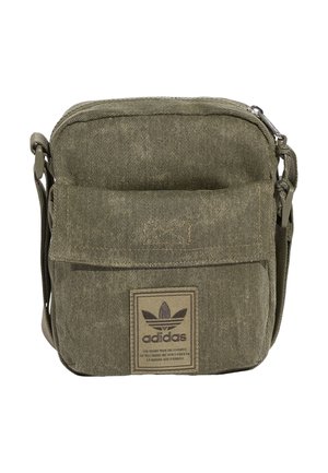 Mała oliwkowozielona torba Adidas na ramię z przednią kieszenią z klapką i regulowanym paskiem, z naszywką z logo Adidas trefoil z przodu.