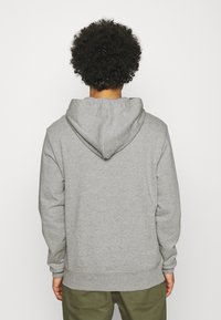 Felpa grigia con cappuccio regolabile, realizzata in un tessuto morbido. Presenta polsini e orlo a coste, vestibilità comoda, con una vista posteriore semplice.