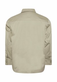 Vue de dos d'une chemise beige à manches longues avec poignets boutonnés et col, présentée sur un fond blanc uni.