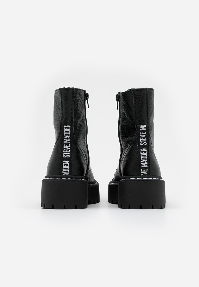 Stivali ankle in pelle nera con finitura texture, suole a piattaforma spessa, chiusura con zip e dettagli del logo bianco sui lati.
