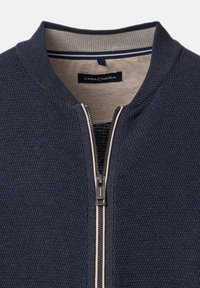 Mörkblå texturerad zip-up tröja med beige innerkrage och Casa Moda-märkesetikett inuti nacken.