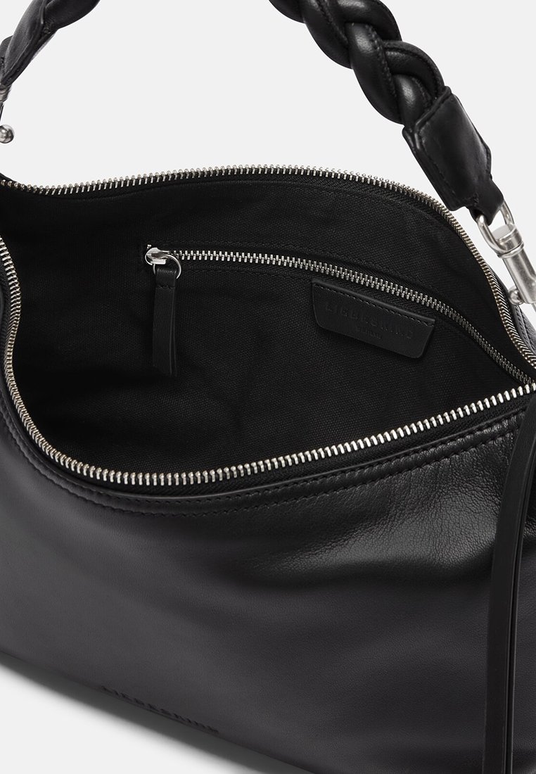 Schwarze Lederhandtasche mit geflochtenem Griff, geöffnet, um das Innere mit schwarzem Stofffutter und kleiner Reißverschlusstasche mit Ledergriff zu zeigen.