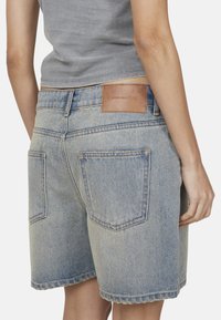 Szorty dżinsowe w jasnoniebieskim kolorze z surowym wykończeniem, z dwiema tylnymi kieszeniami i skórzaną metką marki na pasku. Miękka tekstura i klasyczny krój.