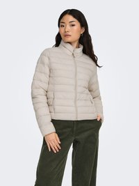 Hellbeige Steppjacke mit hohem Kragen und kontrastierendem Reißverschluss. Verfügt über horizontale Steppmuster und elastische Bündchen.