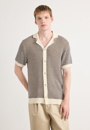 Short-sleeve knit shirt with a textured brown pattern and cream-colored collar and cuffs. Features a button-down front.