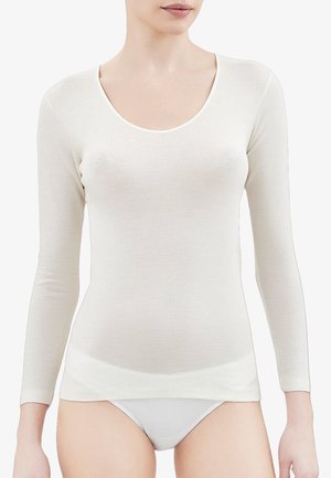 Maglietta a maniche lunghe di un leggero beige con scollatura a barchetta, realizzata in un tessuto morbido e liscio. Design semplice senza motivi o dettagli visibili.
