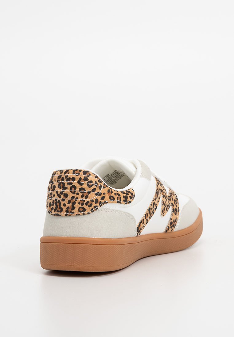 Zapatilla blanca con acentos en beige y un talón con estampado de leopardo. Presenta una suela de goma y materiales texturizados. Logo lateral en color contrastante.