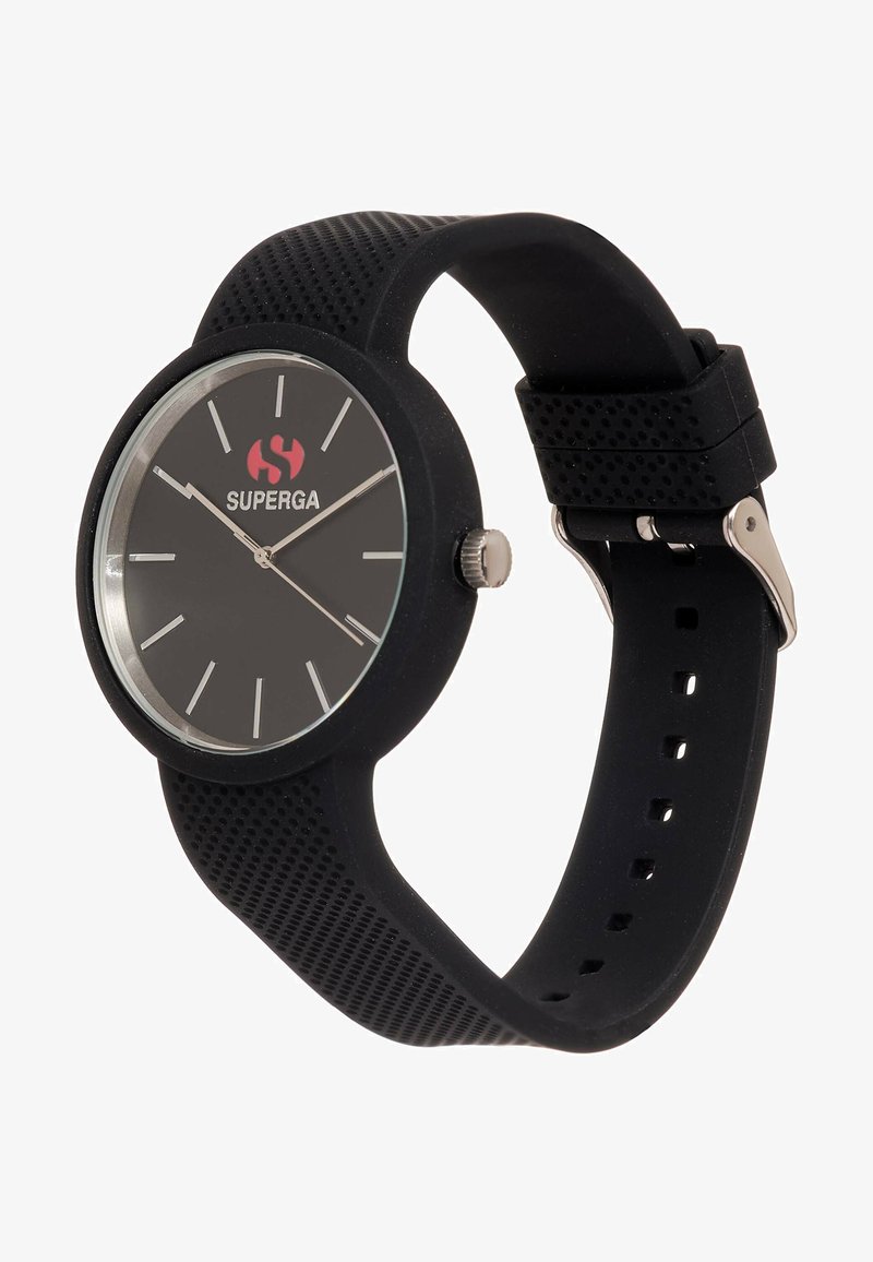 Mustalääne kell, millel on ümmargune kellanägu, hõbedased aktsendid ja eristuvad tunni markerid. Omab tekstuuri strapile ning punast logo.