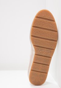 Světle růžová bota s texturovanou gumovou podrážkou. Podrážka má vlnitý vzor a logo značky "Gabor." Pevný design, detaily s prošíváním na okrajích.