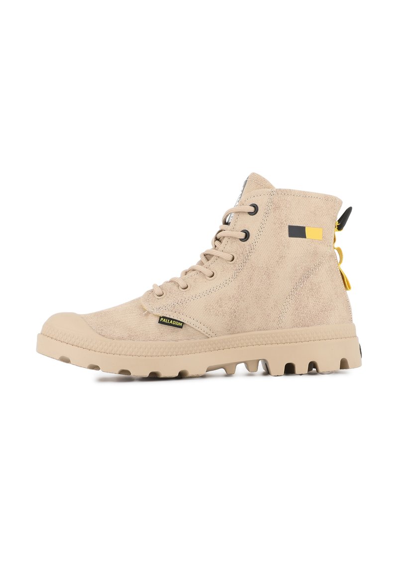 Botas altas beige hechas de tejido texturizado, con suela de goma, parte delantera con cordones y pequeña etiqueta de logo con acentos en amarillo y negro.