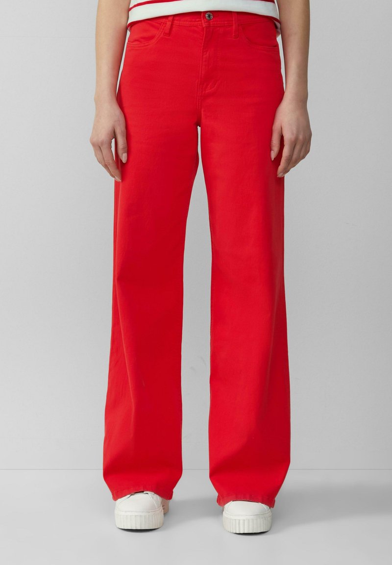 Rote weit geschnittene Jeans aus Baumwolle mit glatter Textur, ausgestattet mit einem Frontknopfverschluss und einem klassischen Fünf-Taschen-Design.