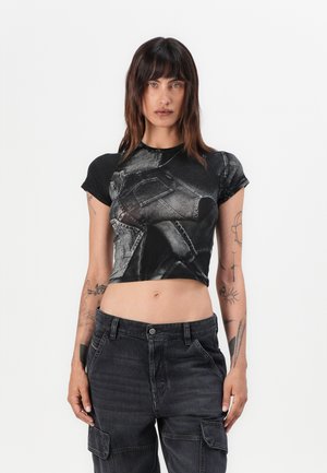 Black cropped t-shirt featuring a denim pattern, round neckline, and short sleeves, paired with high-waisted dark cargo pants with pockets.
