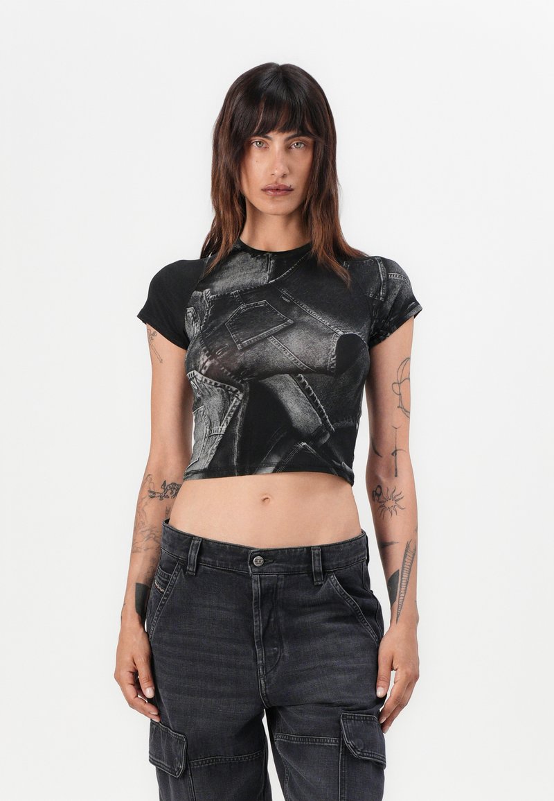 Black cropped t-shirt featuring a denim pattern, round neckline, and short sleeves, paired with high-waisted dark cargo pants with pockets.