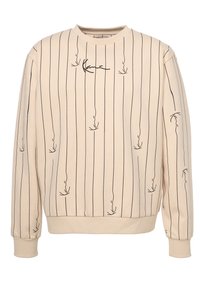Felpa beige con strisce verticali nere e design astratti, colletto rotondo e polsini e orlo a costine. Tessuto morbido e texturizzato.