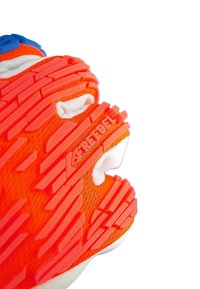 Baskets de sport orange avec semelle en caoutchouc texturé. Présente des motifs de bande de roulement proéminents et un accent de marque. Dessus en tissu respirant.