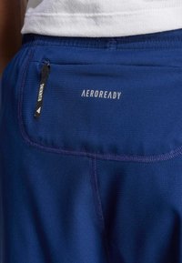Granatowe szorty do biegania z teksturowaną powierzchnią, z metką AeroReady i małą kieszonką na zamek do przechowywania.
