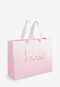 Rožinė popierinė pirkinių maišelis su sustiprintomis rankenomis ir blizgiu paviršiumi. Priekyje pavaizduotas auksinis užrašas "BAKER BY TED BAKER".